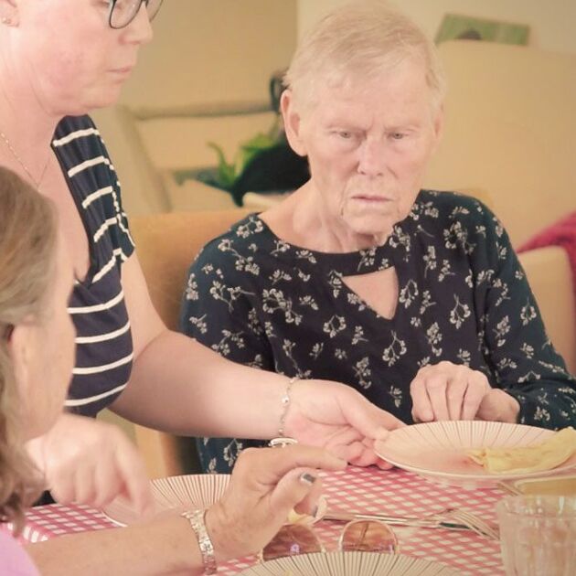 Vrouw helpt oudere vrouw met opruimen
