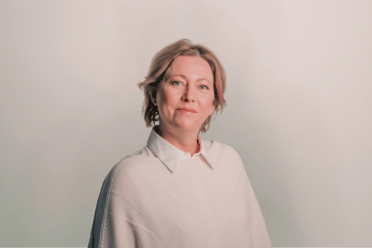 Ulrieke medewerker Qredits vrouw in licht shirt voor grijze achtergrond