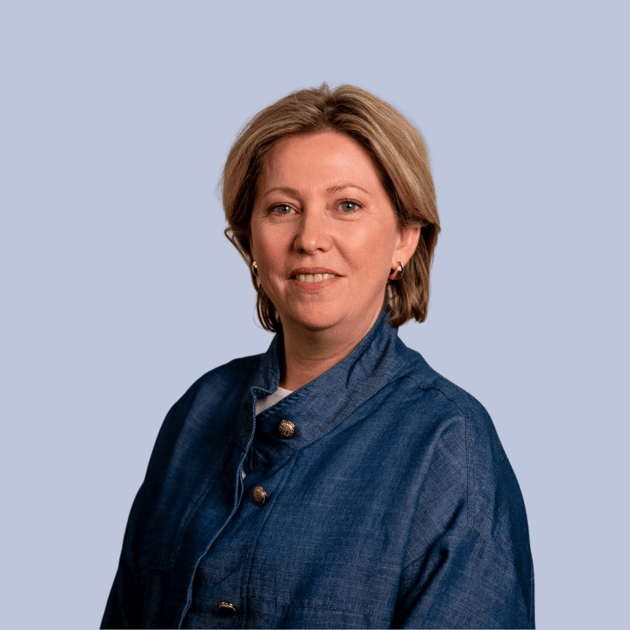 medewerker Qredits Ulrieke de Jong vrouw in licht shirt voor grijze achtergrond