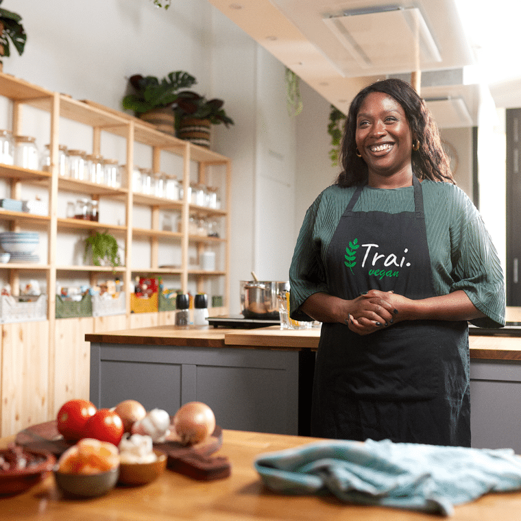 Vrouw staat in de kijken en kijkt lachend naar voren