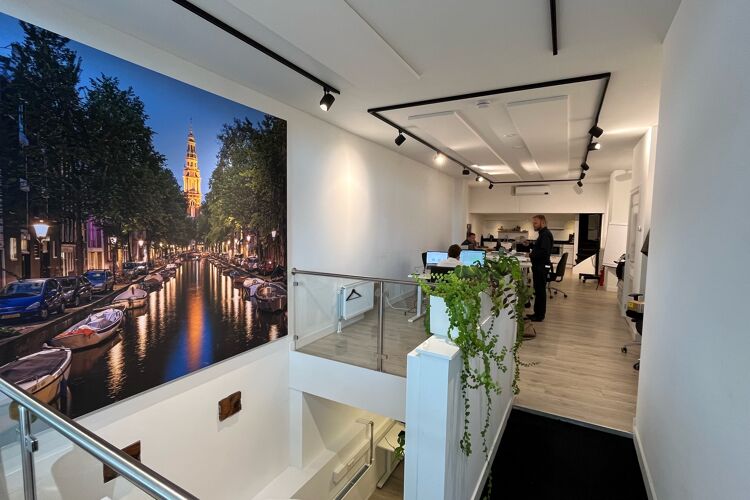 Witte binnenkant gebouw met planten en foto aan de muur