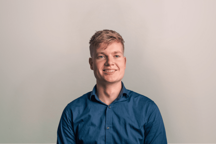 Lennart medewerker Qredits man in blauw shirt voor grijze achtergrond