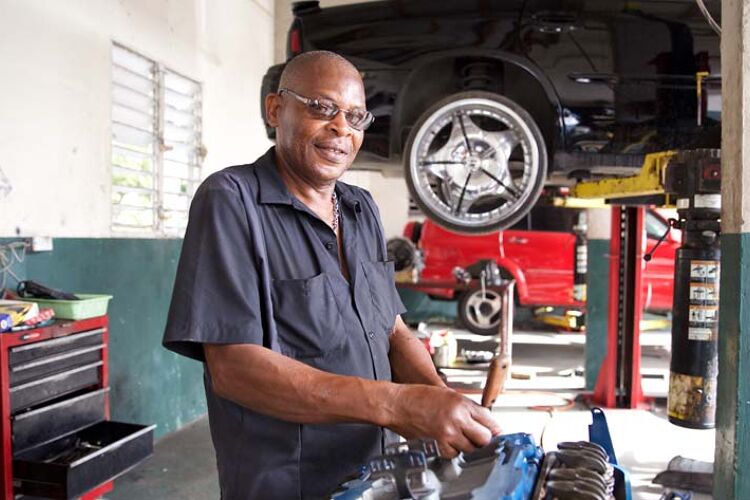 automonteur in werkplaats met motorblok