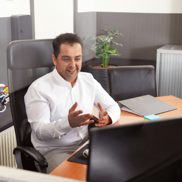 Man in wit shirt praat tegen iemand op zijn computer
