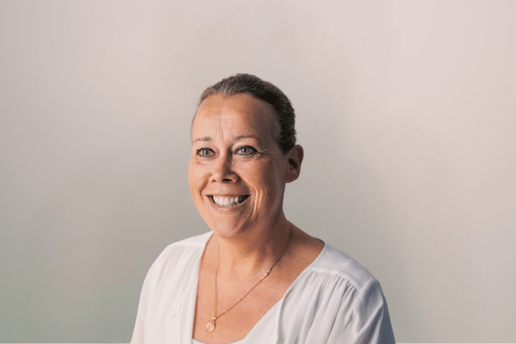 Maud medewerker Qredits vrouw in wit shirt voor grijze achtergrond