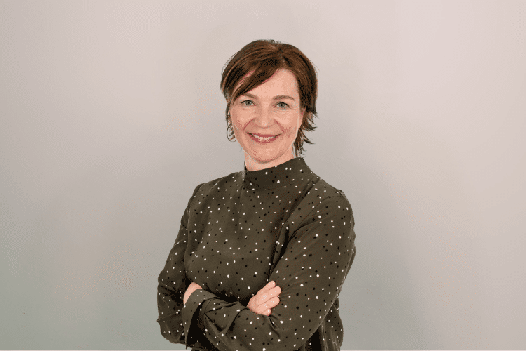 Mirjam medewerker Qredits vrouw in groen shirt voor grijze achtergrond