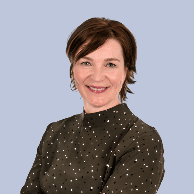 medewerker Qredits Mirjam van Duijn vrouw in groen shirt voor grijze achtergrond