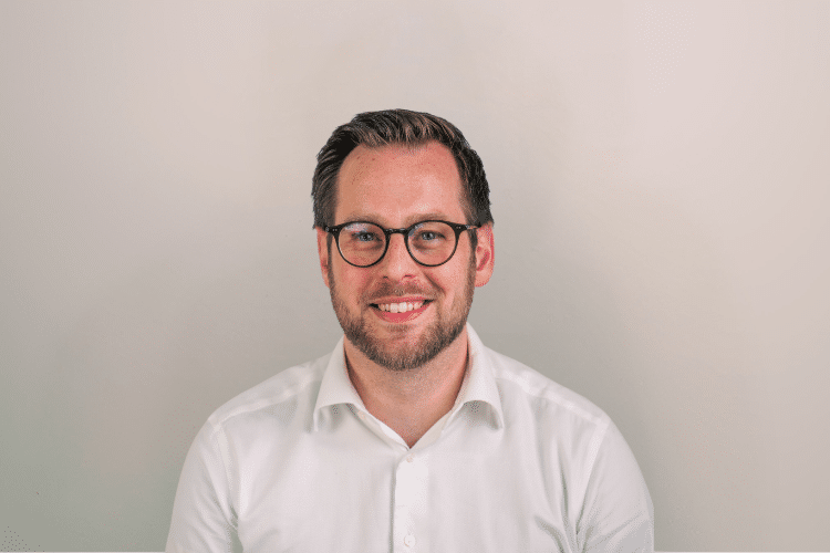 Rik medewerker Qredits man in wit shirt voor grijze achtergrond