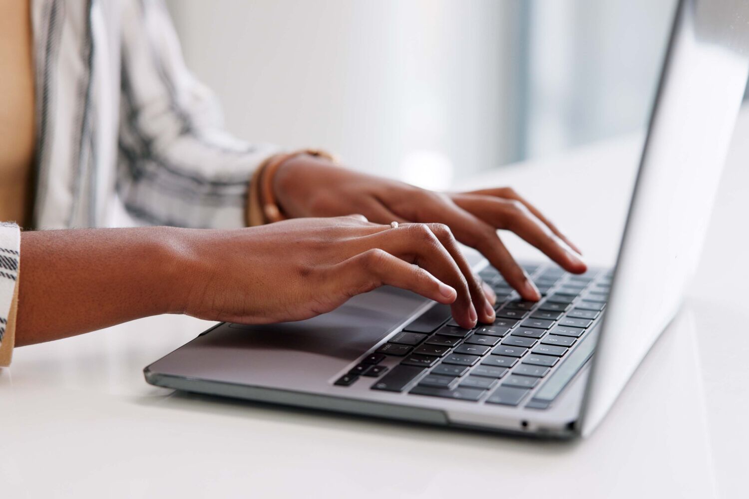 Vrouw typt op een laptop.