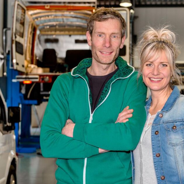 man en vrouw samen in een garage met bestelbusjes.