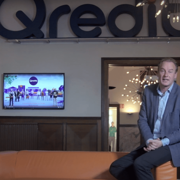 Elwin Groeneveld in pak zit op bank met Qredits 10 jaar