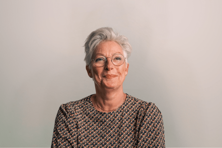 medewerker Qredits Greetje Teunissen vrouw met bril voor grijze achtergrond