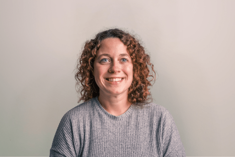 Lisan medewerker Qredits vrouw in grijs shirt voor grijze achtergrond