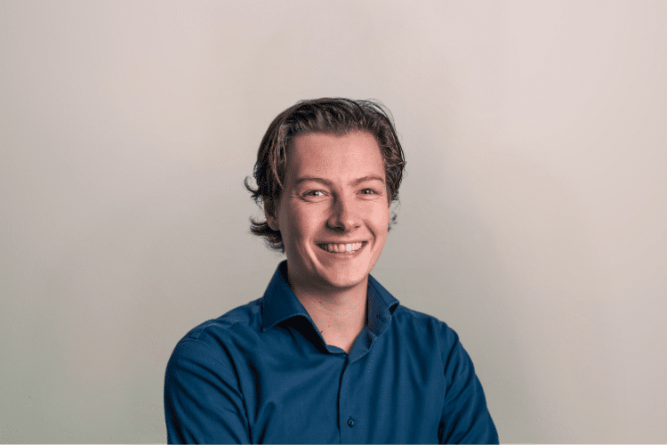 Baruch medewerker Qredits man in blauw shirt voor grijze achtergrond