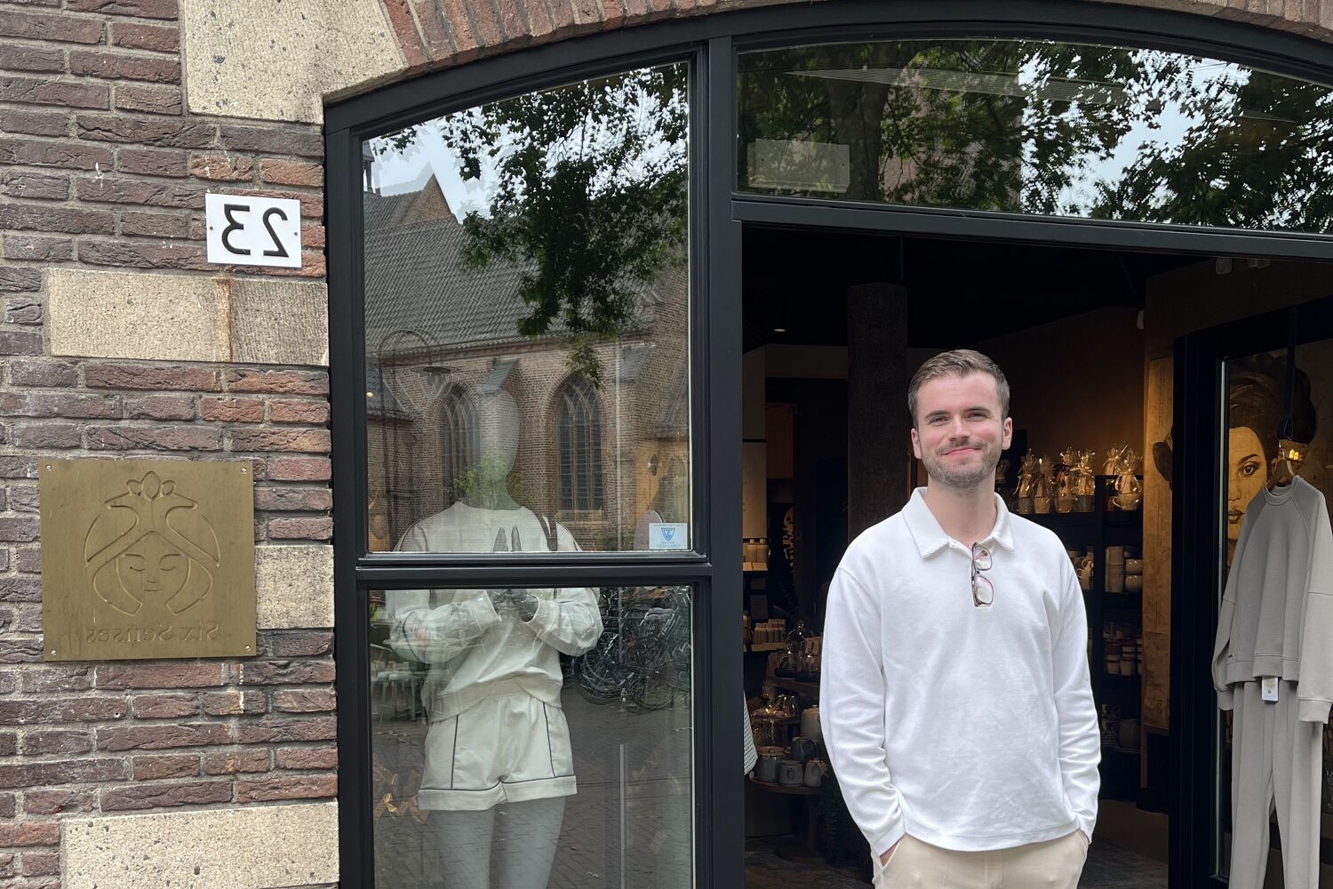 Man staat met de handen in de zak voor een pand.