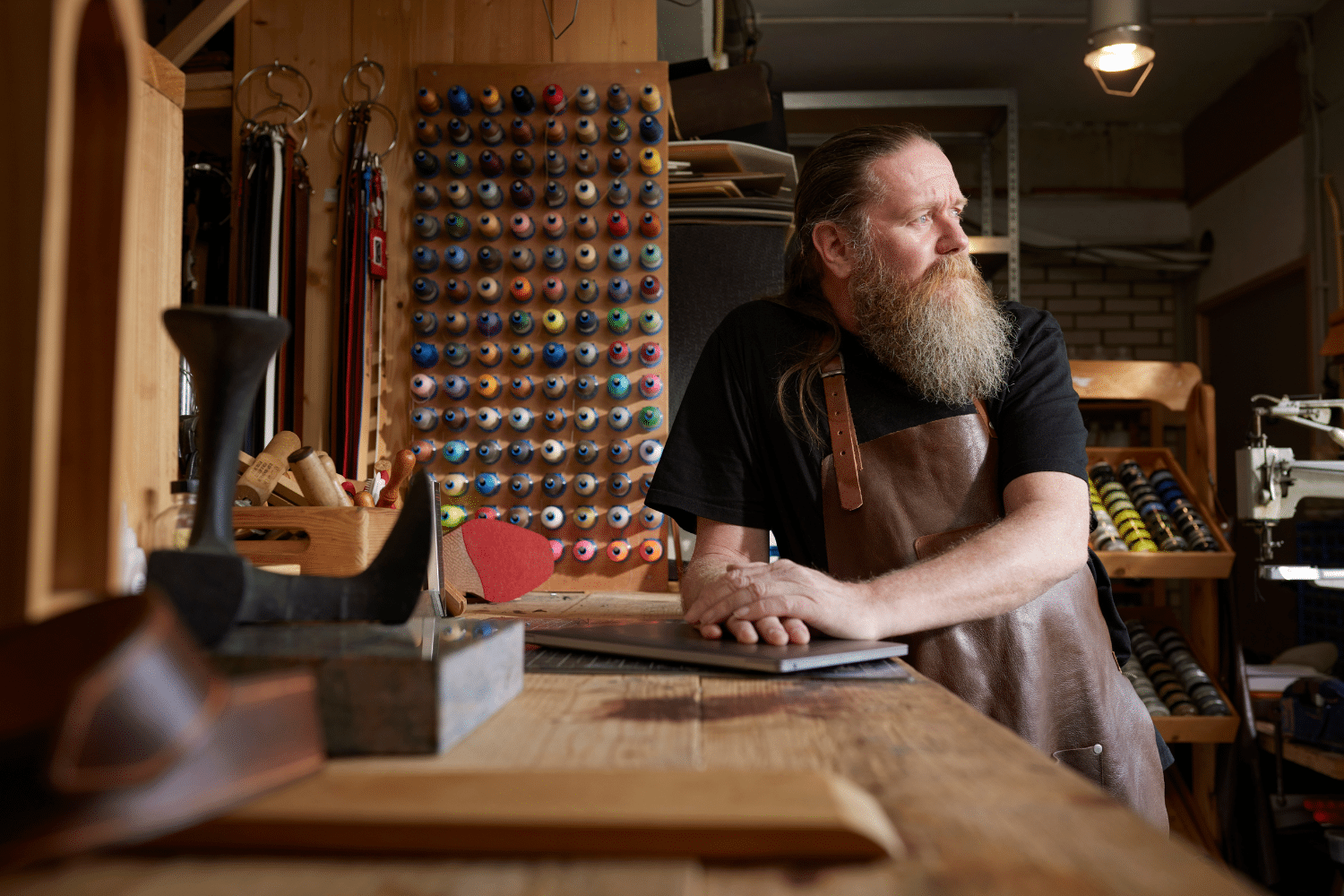 man-staat-in-schoenenatelier man kijkt in de verte en denkt na over zakelijke beslissingen na een coachingsgesprek