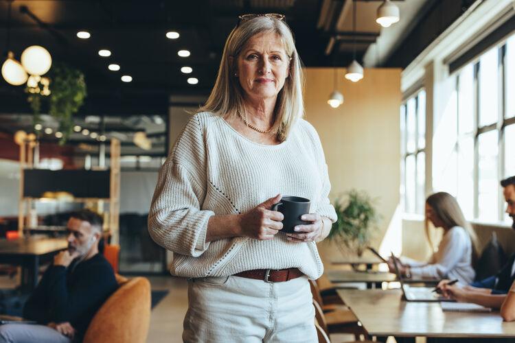 oudere-vrouw-kijkt-serieus-koffie-in-hand