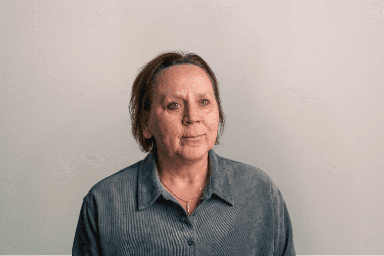 Sylvia  medewerker Qredits vrouw in grijs shirt voor grijze achtergrond