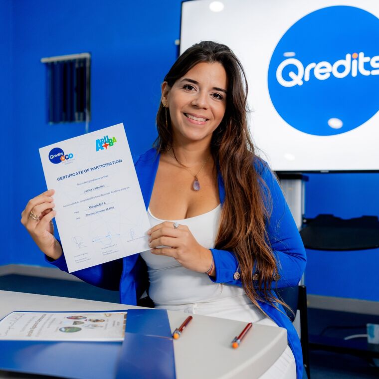 Blije vrouw in blauw jasje houd een papier omhoog in een blauwe kamer met een groot scherm op de achtergrond