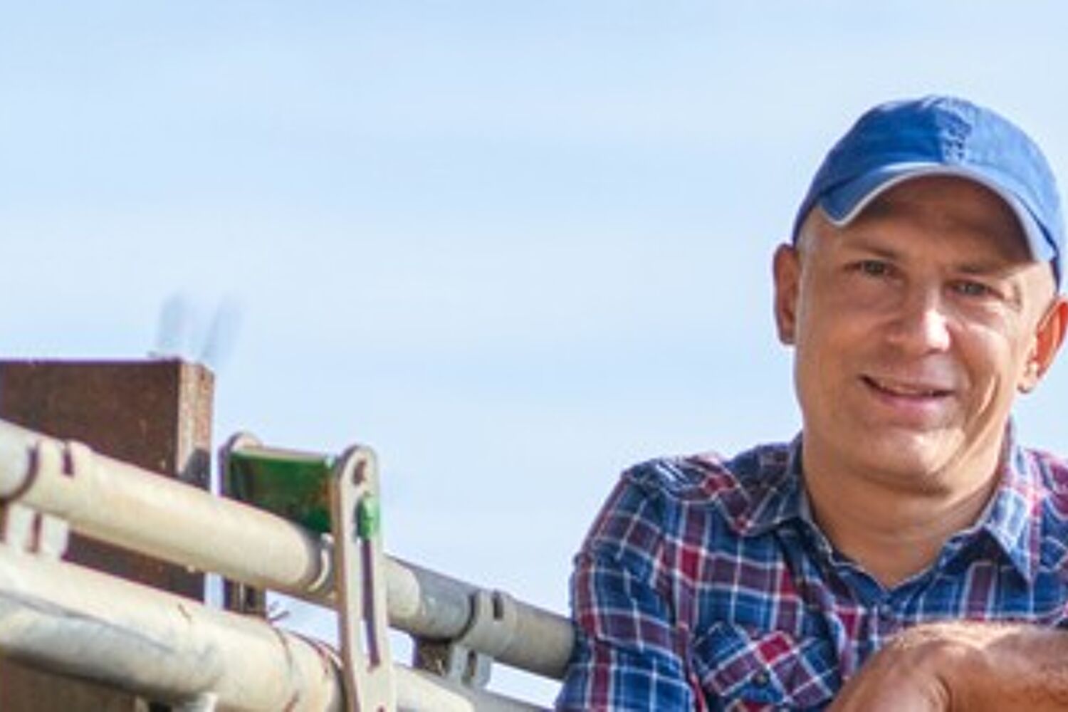 boer leunt op schep naast koe header