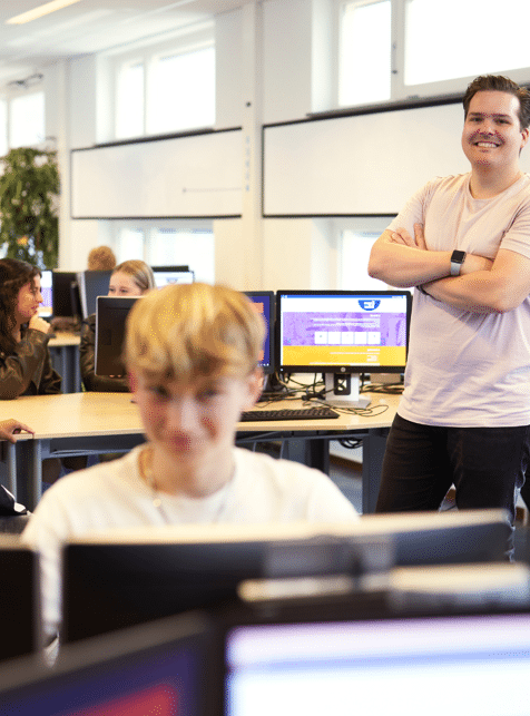 midden in de vmbo klas, staat een trotse docent