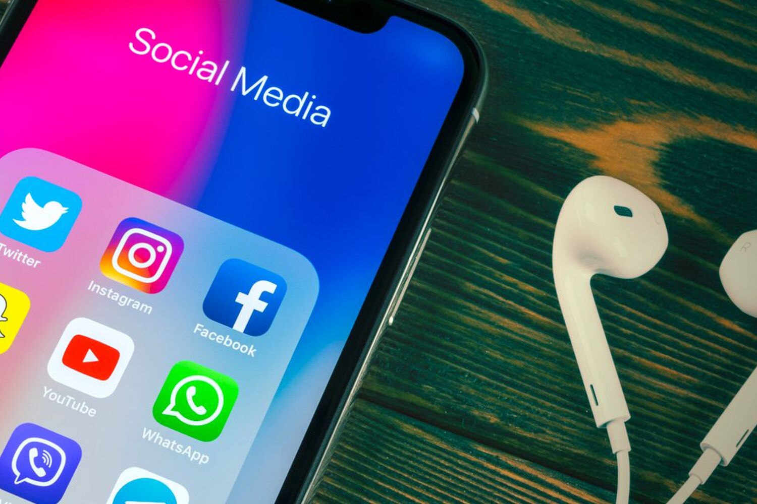 Een telefoon waarop verschillende social media apps te zien zijn. 