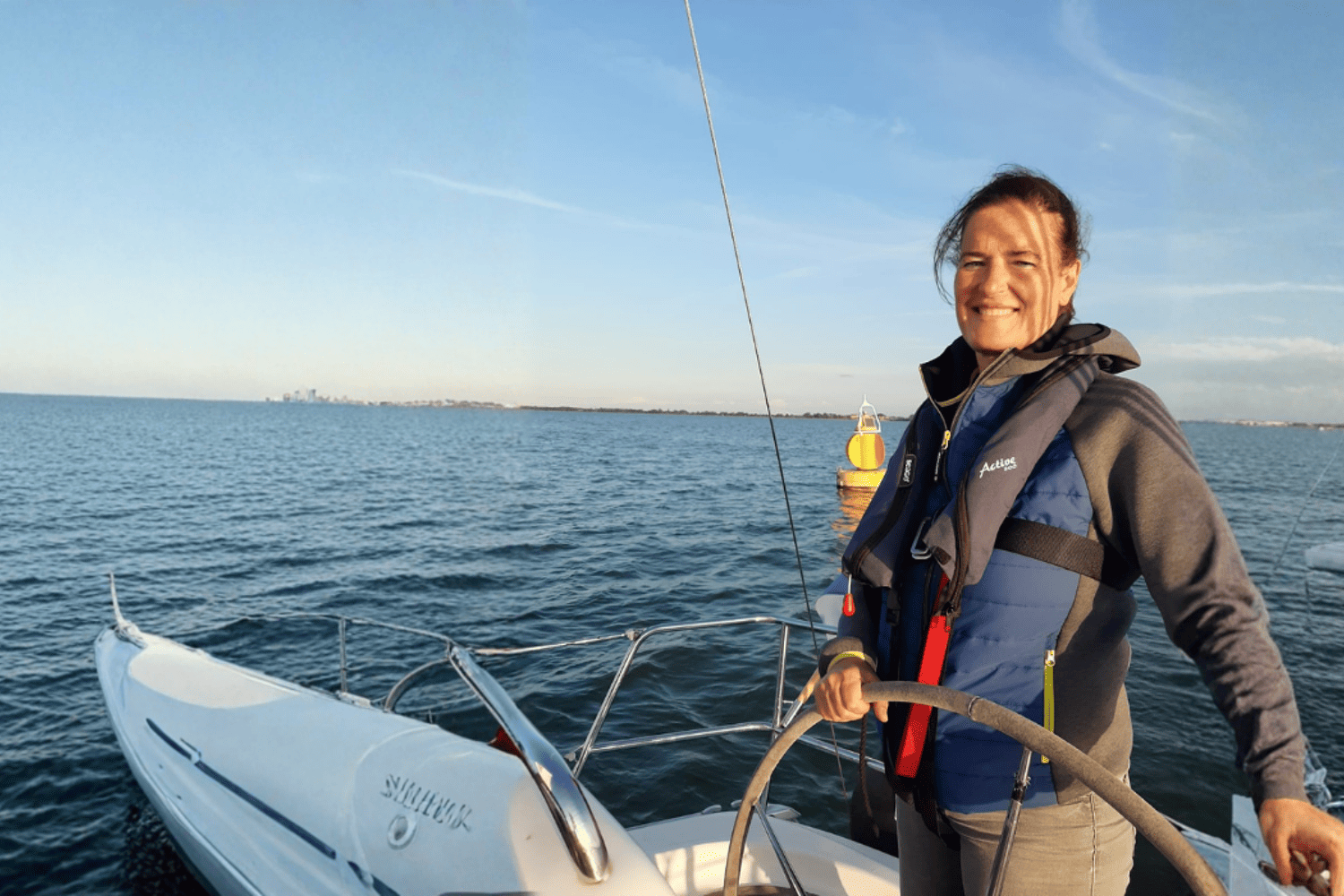 Qredits coach rolande wouda Staat achter het stuur op een boot in de zee
