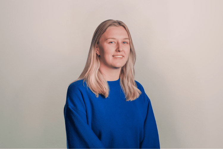 Lotte medewerker Qredits vrouw in blauw shirt voor grijze achtergrond