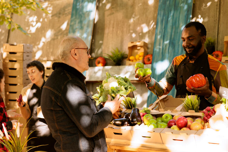 Man-in-gesprek-met-medewerker-groentekraam