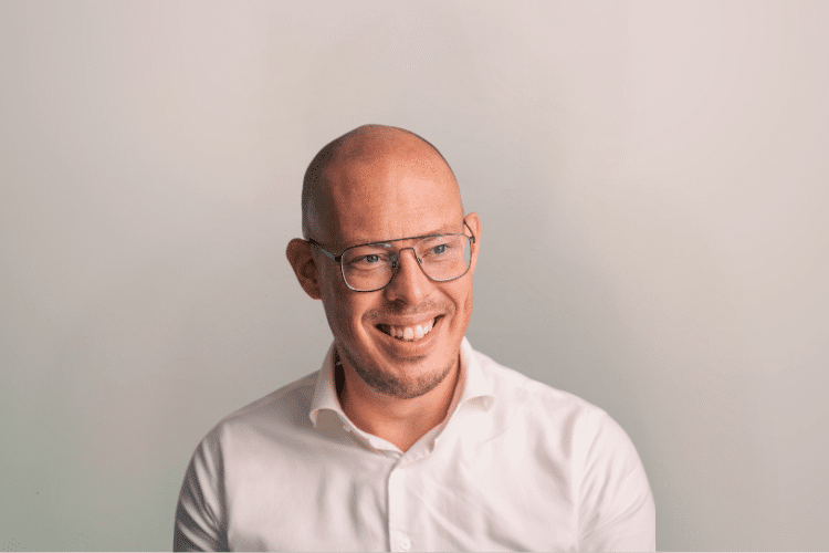 Rick medewerker Qredits man in wit shirt voor grijze achtergrond