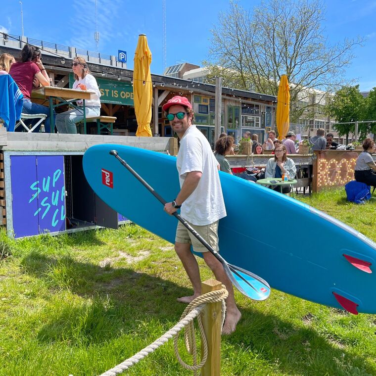 Man haalt een surfboard uit een kast.