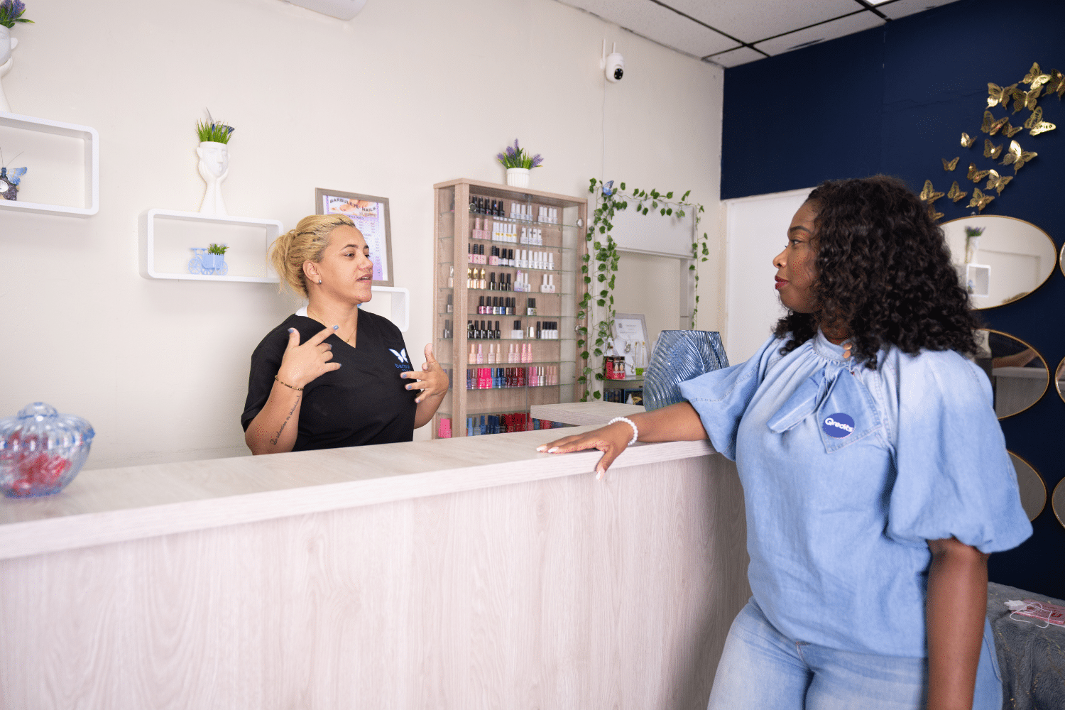 Een gesprek tussen twee vrouwen aan een balie bij een salon.
